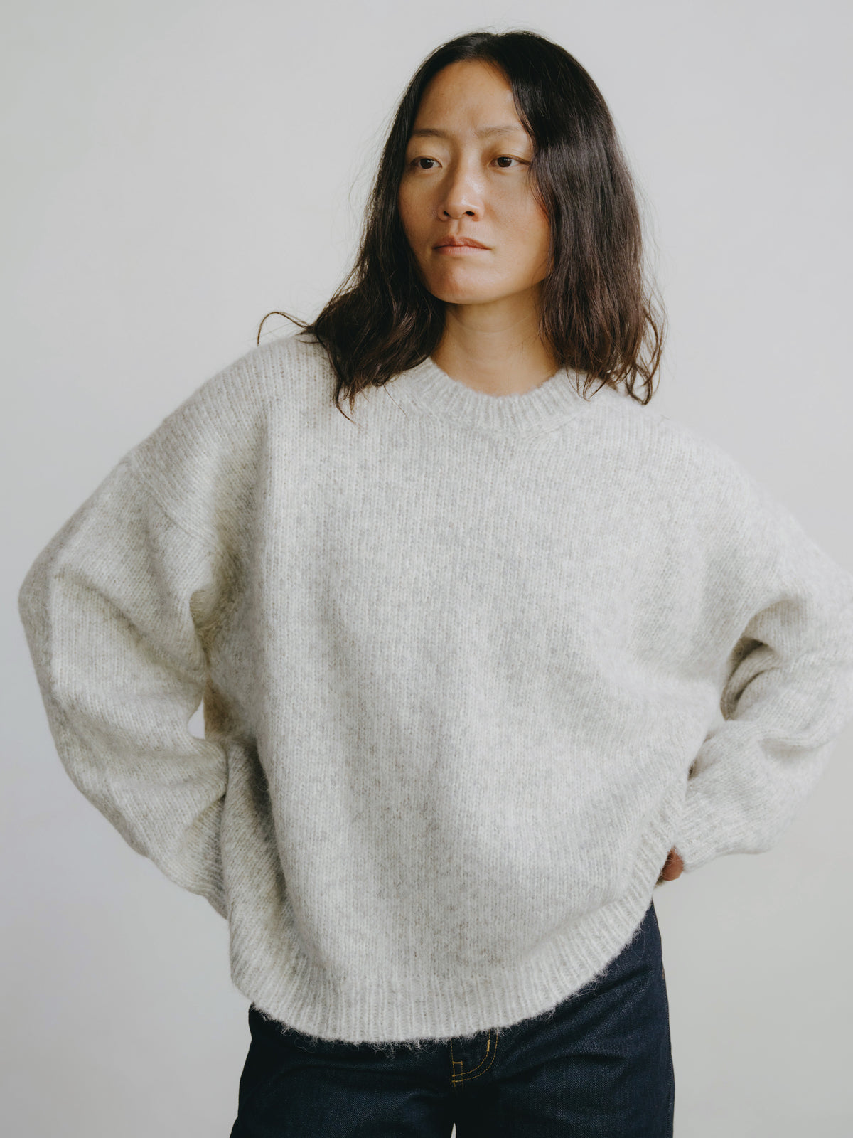 Person wearing a light gray sweater against a plain background