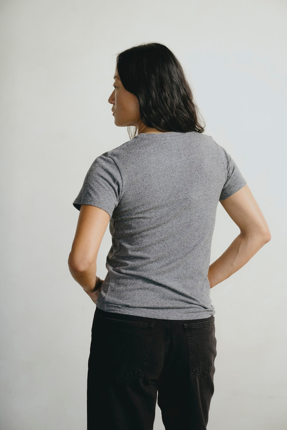 Person wearing a gray t-shirt against a plain background